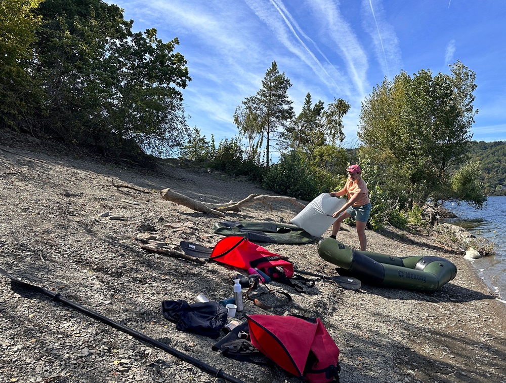 A encher um packraft na margem do lago durante uma aventura de packrafting no Eifel, Alemanha